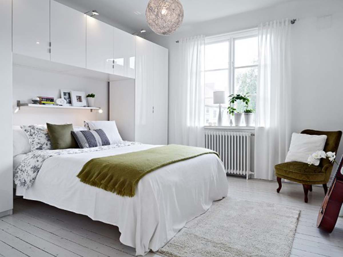 A Simple White Bedroom With A White Bed And White Walls
